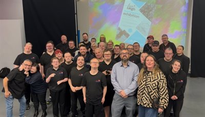 Large group of people in front of a digital screen