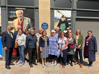 A group photo with the Blue Plaque for George Heaton