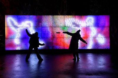 Art installation with the shadows of two people dancing in front