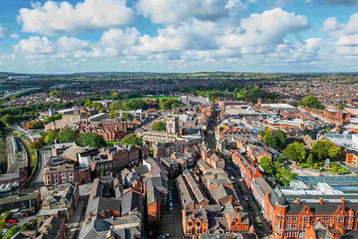 An aerial view of a town centre with rows of houses and buildings on a sunny day