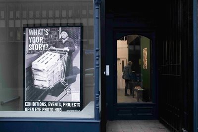 Shop front showing a poster asking 'What's your story?'