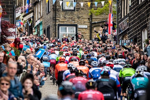 Crowds lining a street as cyclists race along