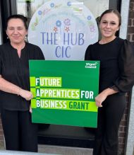 Two women standing in front of The HUB CIC with a FAB grant sign