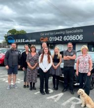 Group of people stood outside a car lease showroom