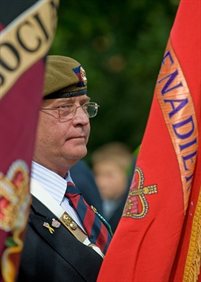 Military veteran standing between two flags