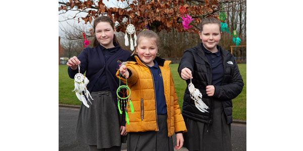 School children holding dreamcatchers outside