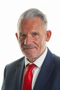 Man with grey hair and a red tie