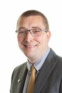 Man with glasses wearing a yellow tie