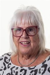 Woman with white hair and red glasses