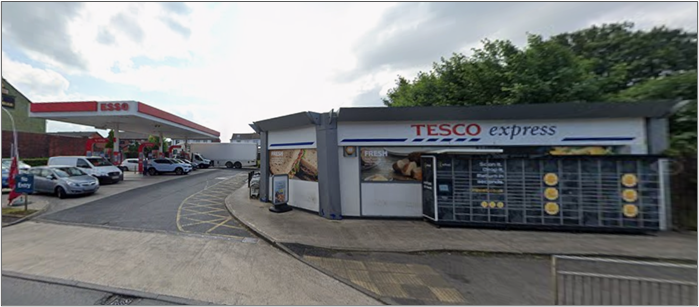 A contemporary photograph of a Tesco Express shop.  Single storey building on the corner of a road.