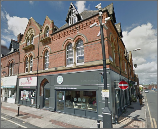 Three-story former hotel building with the ground floor turned into a shop