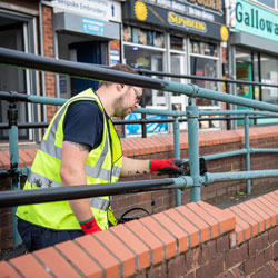 Painting railings in Aspull