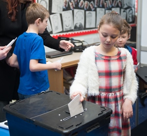 Democracy Services at St Wilfrids School, young girl casting a poll vote