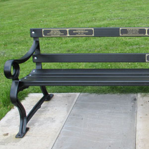Memorial bench with numerous plaques