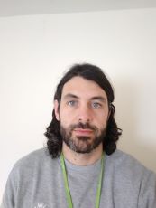 Man with shoulder-length brown hair and a short brown beard